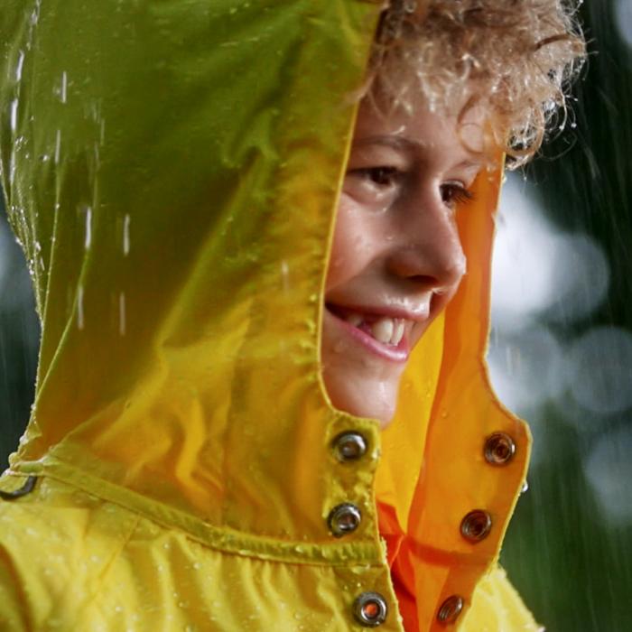 Boy wearing yellow rain jacket with hood still from health insurer video.