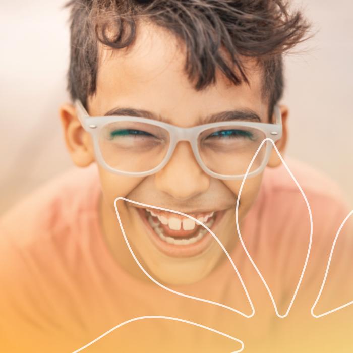 Young boy smiling with orange Chileda gradient on the bottom and see-through Chileda flower in the bottom left corner