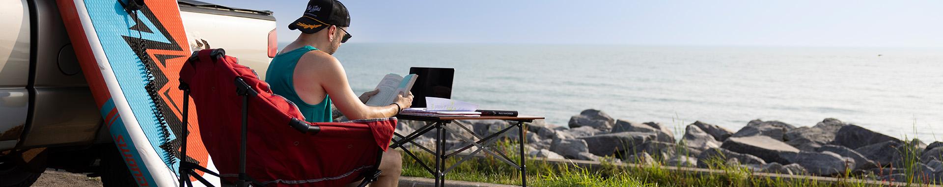 Student doing schoolwork on a beach